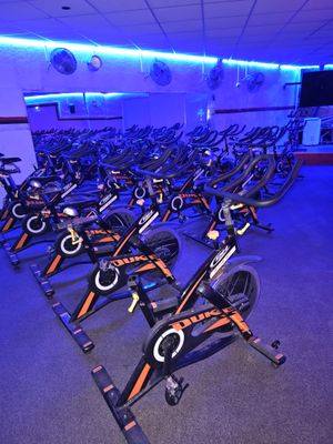a room full of stationary exercise bikes in a gym
