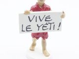 figurine représentant un homme tenant une pancarte sur laquelle on peut lire « Vive le yet »