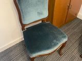 a chair that is next to a dresser in a room