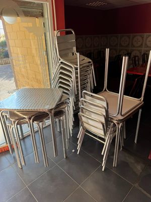 de nombreuses chaises et tables dans une pièce dont l'un des murs est rouge