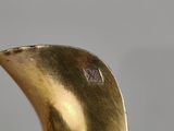 brass sculpture of a bird sitting on top of a wooden table