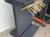 a close up of a rack with clothes hanging on it in a warehouse