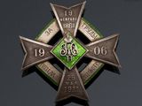 a badge with a cross on it on a black surface