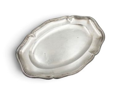 an oval silver plate with a scallop edge on a white surface