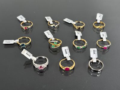 a group of rings with different colored stones on them sitting on a table