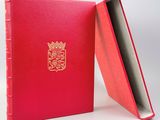un livre rouge orné d'un blason doré sur la couverture