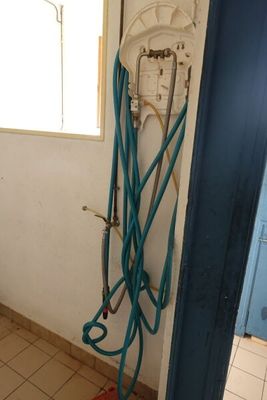 une photo d'une salle de bains avec un tuyau fixé au mur