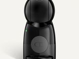 a black coffee maker sitting on top of a white surface