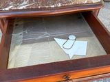a wooden table with a marble top and drawer underneath it