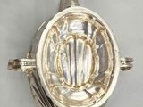 a silver ring with a shell on top of it