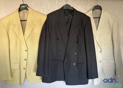 three suits hanging on a wall in a row