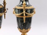 pair of black and gold urns with handles and handles