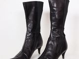 a pair of black leather high heel boots on a white surface