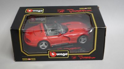 une petite voiture rouge dans une boîte posée sur une table