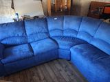 a large blue couch in a room with a wooden floor