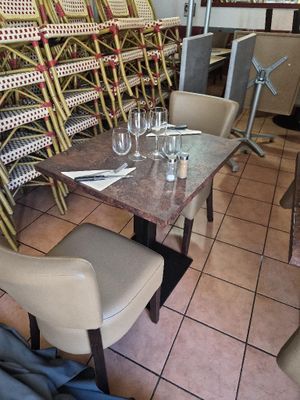 many chairs and tables in a restaurant with wine glasses on the table