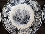 three plates with black and white designs on them on a table