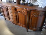 a large wooden sideboard with a vase on top of it