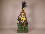 a figurine of a woman sitting on a green chair