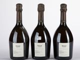 trois bouteilles de vin posées l'une à côté de l'autre sur une table