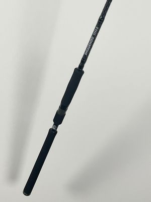 a close up of a fishing rod on a white surface