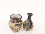 two vases that are sitting side by side on a white surface