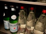 bottles of water are lined up on a shelf in a store