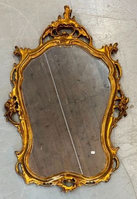 a mirror on the floor with a gold frame on it