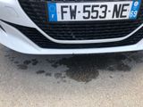 the front of a white car with a number plate on the front of it