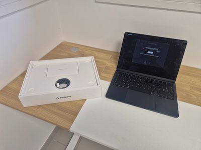 a laptop computer sitting on a table next to a box