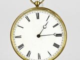 une horloge en or avec des chiffres romains sur le cadran