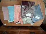 a wooden chest with a bunch of clothing on top of it