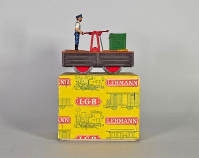 un petit bonhomme en jouet debout sur une boîte posée sur une table