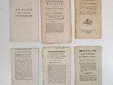 several old books are lined up on a white surface