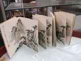 cinq livres exposés sur une table dans une vitrine en verre