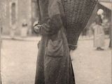 une vieille photo d'une femme portant un panier sur le dos