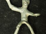 une image représentant une figurine en bronze d'un homme sur fond noir