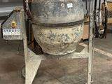 a cement mixer sitting in a garage next to a wall