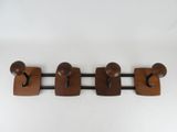 three wooden coat hooks mounted on a wall next to a white wall
