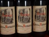 several bottles of red wine are lined up on a shelf