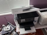 a printer sitting on top of a desk next to a laptop
