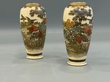 pair of asian vases with flowers and trees on them on a gray surface