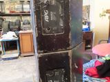 a black refrigerator sitting in the middle of a messy room