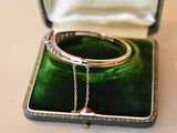 a green velvet case with a silver bracelet inside of it