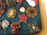 a lot of brooches that are on a tray
