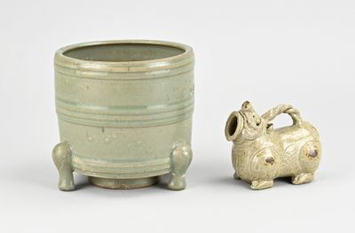 un petit animal en céramique posé à côté d'un pot sur une table
