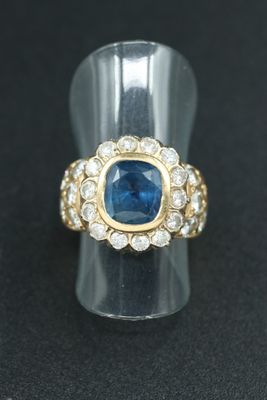 a close up of a ring with a blue sapphire and white diamonds
