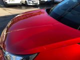 a red car parked in a parking lot with other cars
