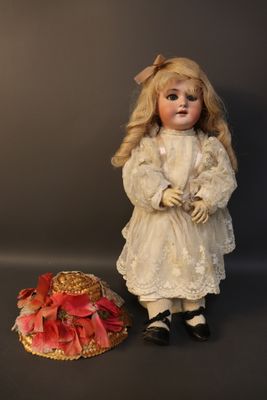 a doll that is standing next to a hat