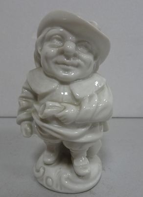 une petite figurine blanche représentant un homme coiffé d'un chapeau